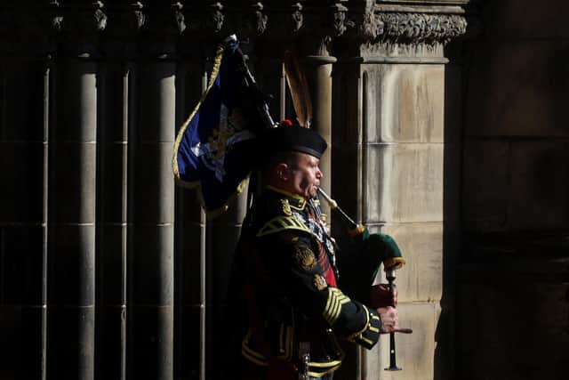 A piper forms part of the Queen's coffin procession out of the St Giles' Cathedral on Tuesday, September 13, 2022 ahead of its journey to Edinburgh Airport and then Buckingham Palace.  Photo by Kai Pfaffenbach - WPA Pool/Getty Images.