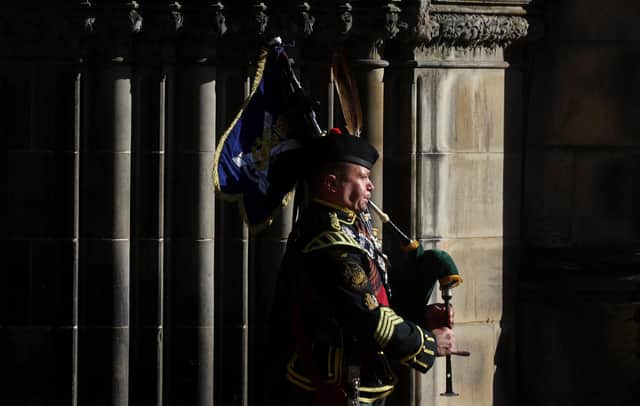 A piper forms part of the Queen's coffin procession out of the St Giles' Cathedral on Tuesday, September 13, 2022 ahead of its journey to Edinburgh Airport and then Buckingham Palace.  Photo by Kai Pfaffenbach - WPA Pool/Getty Images.