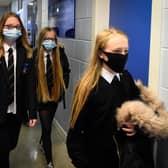 Pupils wearing face coverings in a school corridor (Photo by ANDY BUCHANAN/Digital/AFP via Getty Images)