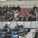 Wayne Rooney (centre of picture, wearing cap) was an interested spectator in the DW Stadium directors box on Monday night