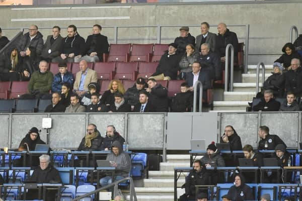 Wayne Rooney (centre of picture, wearing cap) was an interested spectator in the DW Stadium directors box on Monday night