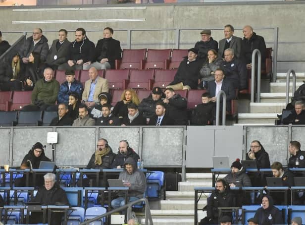 <p>Wayne Rooney (centre of picture, wearing cap) was an interested spectator in the DW Stadium directors box on Monday night</p>