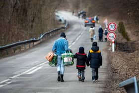 A woman with two children and carrying bags walk on a street to leave Ukraine, following Russia's invasion. Photo by Peter Lazar/AFP via Getty Images
