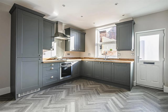 The fitted kitchen has integrated appliances and solid wood worktops.