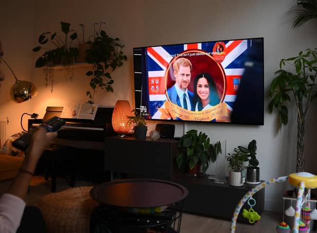 <p>A woman watches an episode of the newly released Netflix docuseries "Harry and Meghan" about Britain's Prince Harry, Duke of Sussex, and Britain's Meghan, Duchess of Sussex, in London. Picture: Daniel Leal/AFP via Getty Images</p>