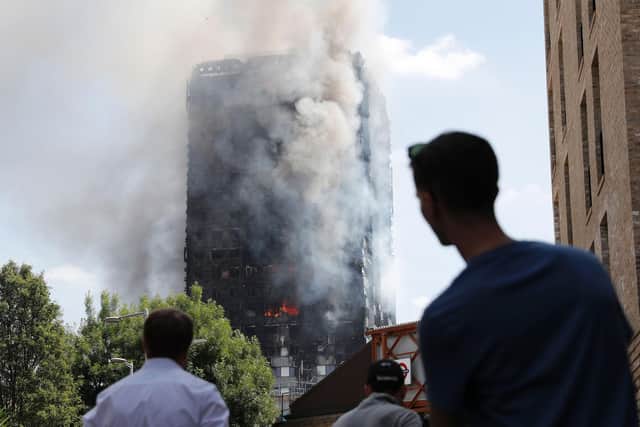 Pedestrians look up towards Grenfell Tower, a residential block of flats in west London on June 14, 2017, as firefighters continue to control a fire that engulfed the building in the early hours of the morning. The news comes as rules are expected to change in Hampshire over how fire crews tackle similar high-rise fires. Photo: Adrian Denniss/AFP via Getty Images.