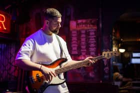 Musician performs on stage at Greene King pub