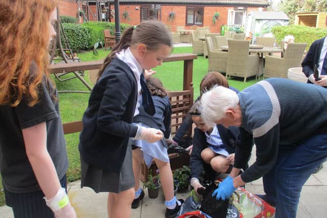 Billy, a former gardener, in Rose Court's garden area with pupils from St Mary’s Primary School